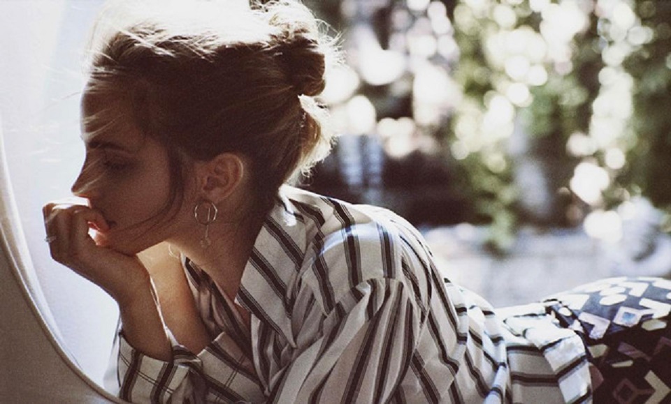 Emma Watson in stripe shirt looking pensive