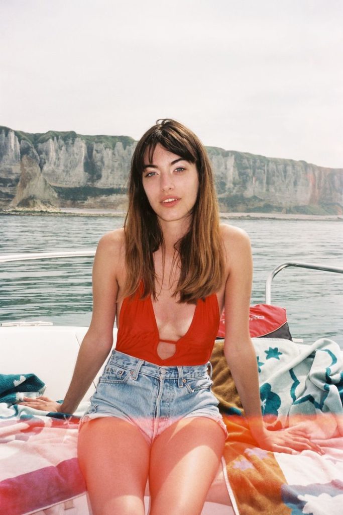 Louise in jean shorts and red top on a boat